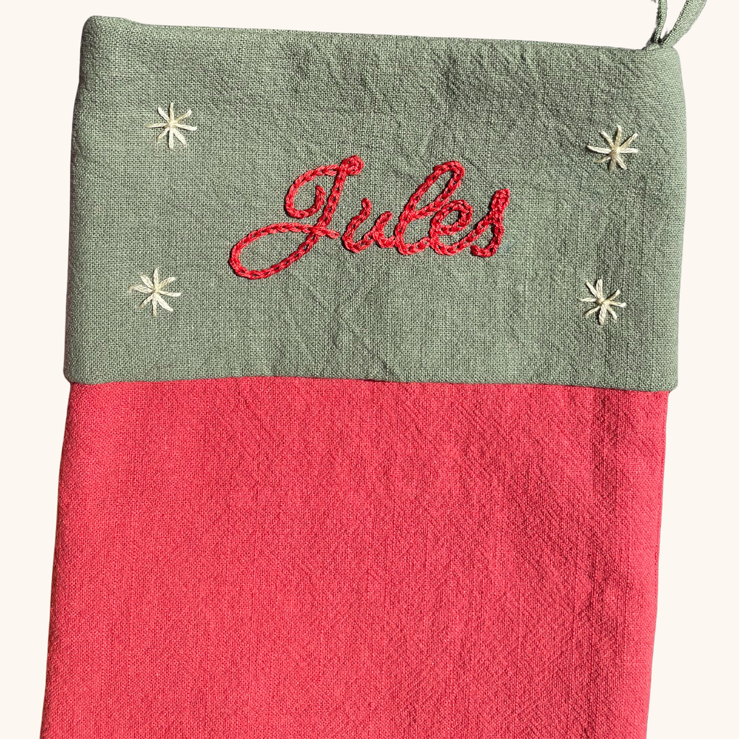 Détail de la broderie prénom sur chaussette de Noël artisanale – fil DMC, brodée main en France par Savane Paris. Couleur rouge.