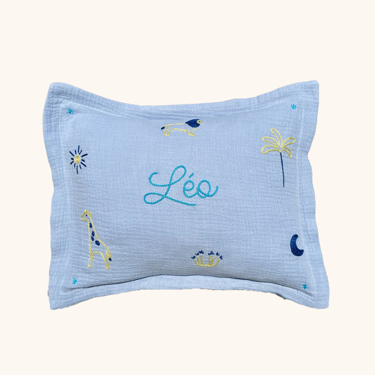 coussin gaze de coton bleu ciel personnalisé brodé main prénom et motifs de la savane lion girafe soleil lune palmier fleur idée cadeau de naissance décoration chambre bébé enfant