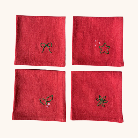Serviette de table 35×35 cm brodée main motif houx, étoiles, nœud cadeau, feuillage d'hiver – linge de table artisanal et festif Savane Paris, confectionné en France, édition limitée de Noël. Couleur rouge.