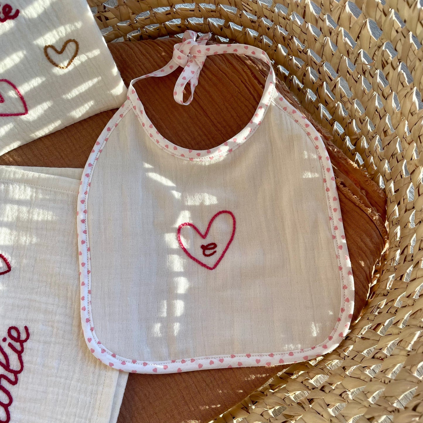 Bavoir bébé personnalisé brodé à la main avec un cœur et une initiale, en coton doux, collection Petits Cœurs Savane, cadeau de naissance artisanal.