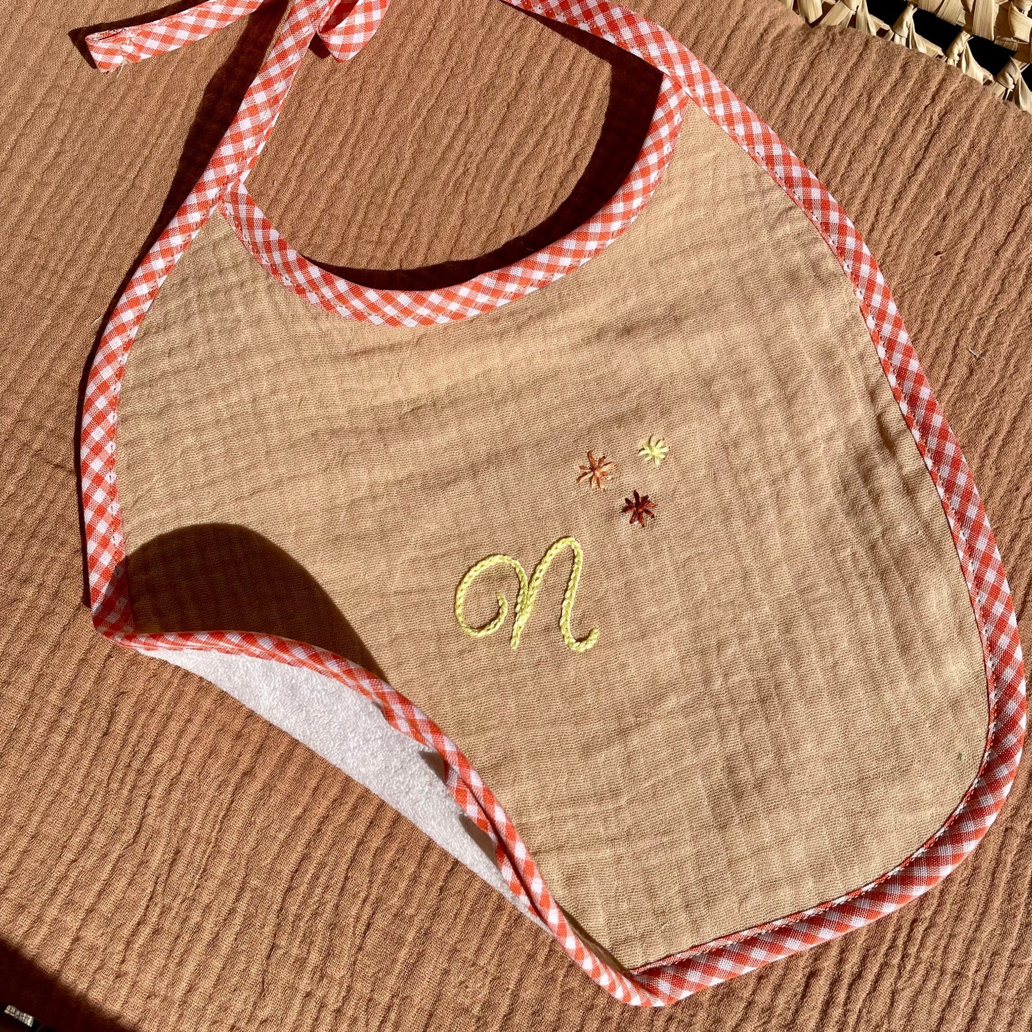 Détail broderie main point de chaînette bavoir Savane