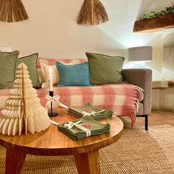Canapé décoré d’un coussin de Noël brodé Savane Paris, ambiance chaleureuse et artisanale dans la Maison de Noël. Au Domaine de la Bastidonne à Céreste-en-Luberon. 