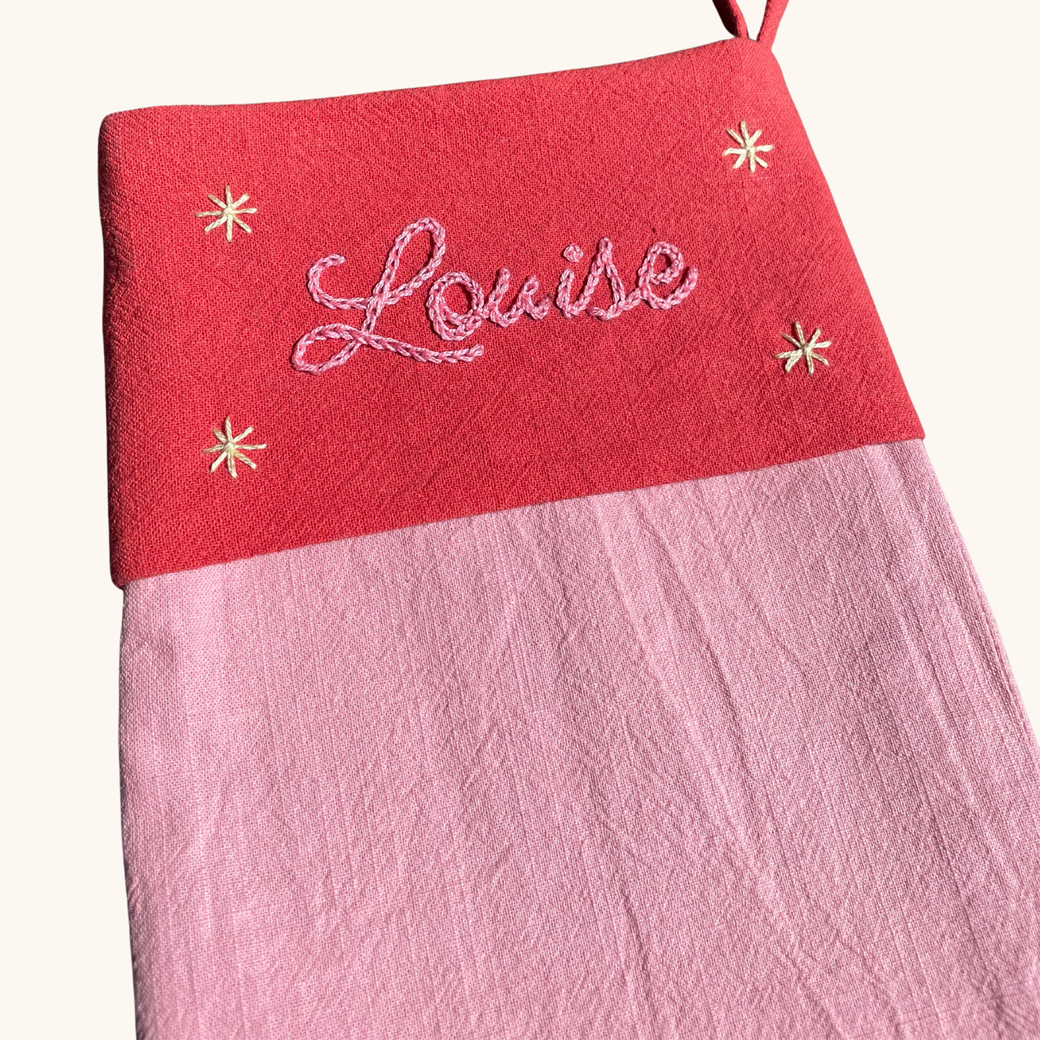 Détail de la broderie prénom sur chaussette de Noël artisanale – fil DMC, brodée main en France par Savane Paris. Couleur rose. 