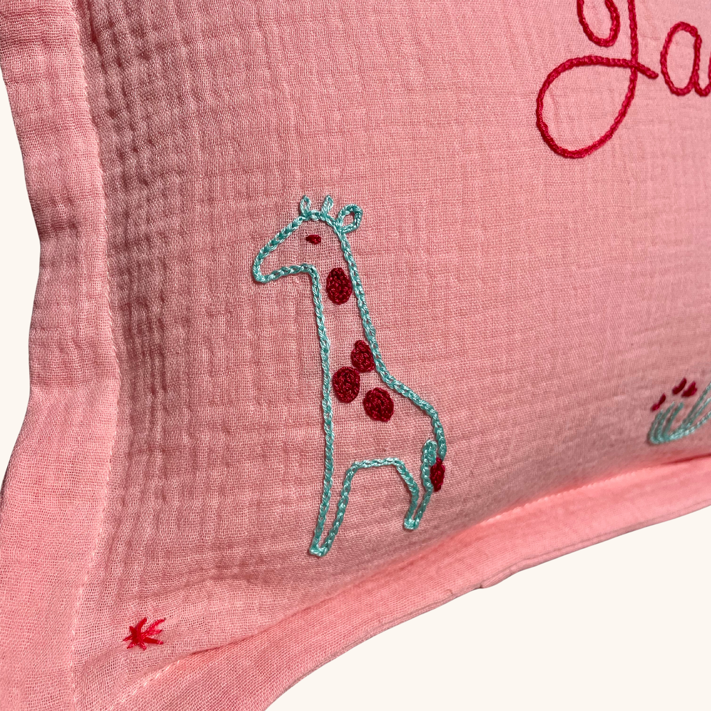 Détail de la broderie girafe sur coussin de naissance rose Savane Paris, création artisanale brodée à la main en France.