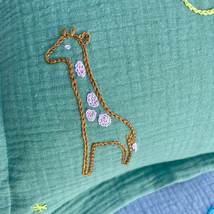 Motif girafe brodé à la main sur coussin de naissance vert Savane Paris en gaze de coton
