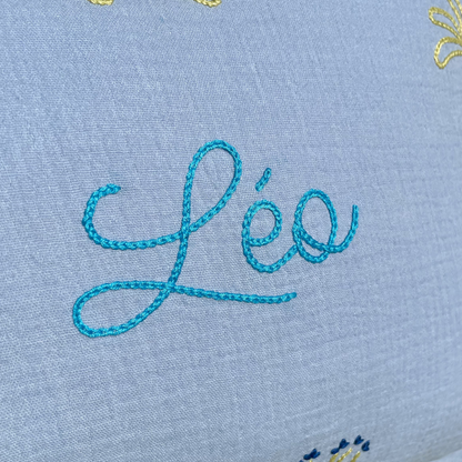 coussin bleu ciel gaze de coton zoom broderie prénom réalisée à la main au point de chaînette. Idée cadeau de naissance décoration chambre bébé et enfant 