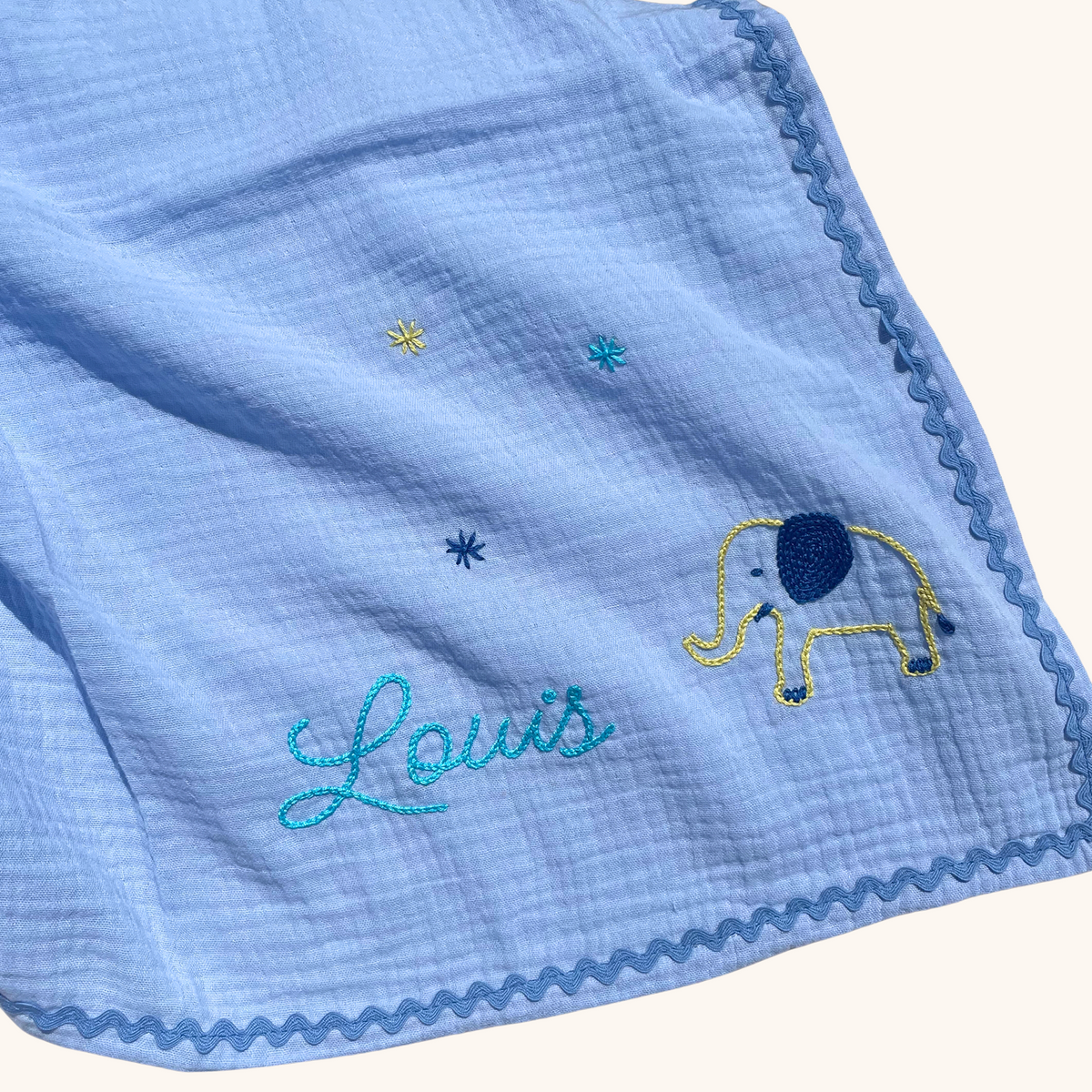 Lange bébé personnalisé bleu avec prénom Louis et éléphant brodés à la main au point de chaînette.