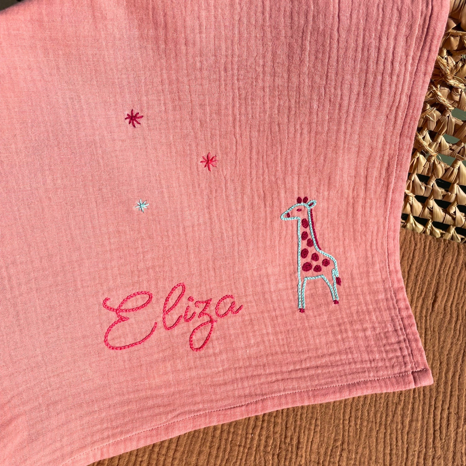 Lange prénom Eliza brodé au point de chaînette avec motif girafe et étoiles de la savane sur double gaze de coton rose, idée cadeau pour liste de naissance.