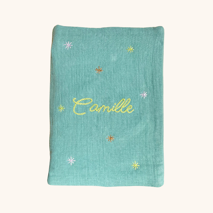 Protège carnet de santé personnalisé vert sauge, brodé main au prénom et décoré d’étoiles – cadeau de naissance artisanal et poétique signé Savane Paris, fabriqué en France.