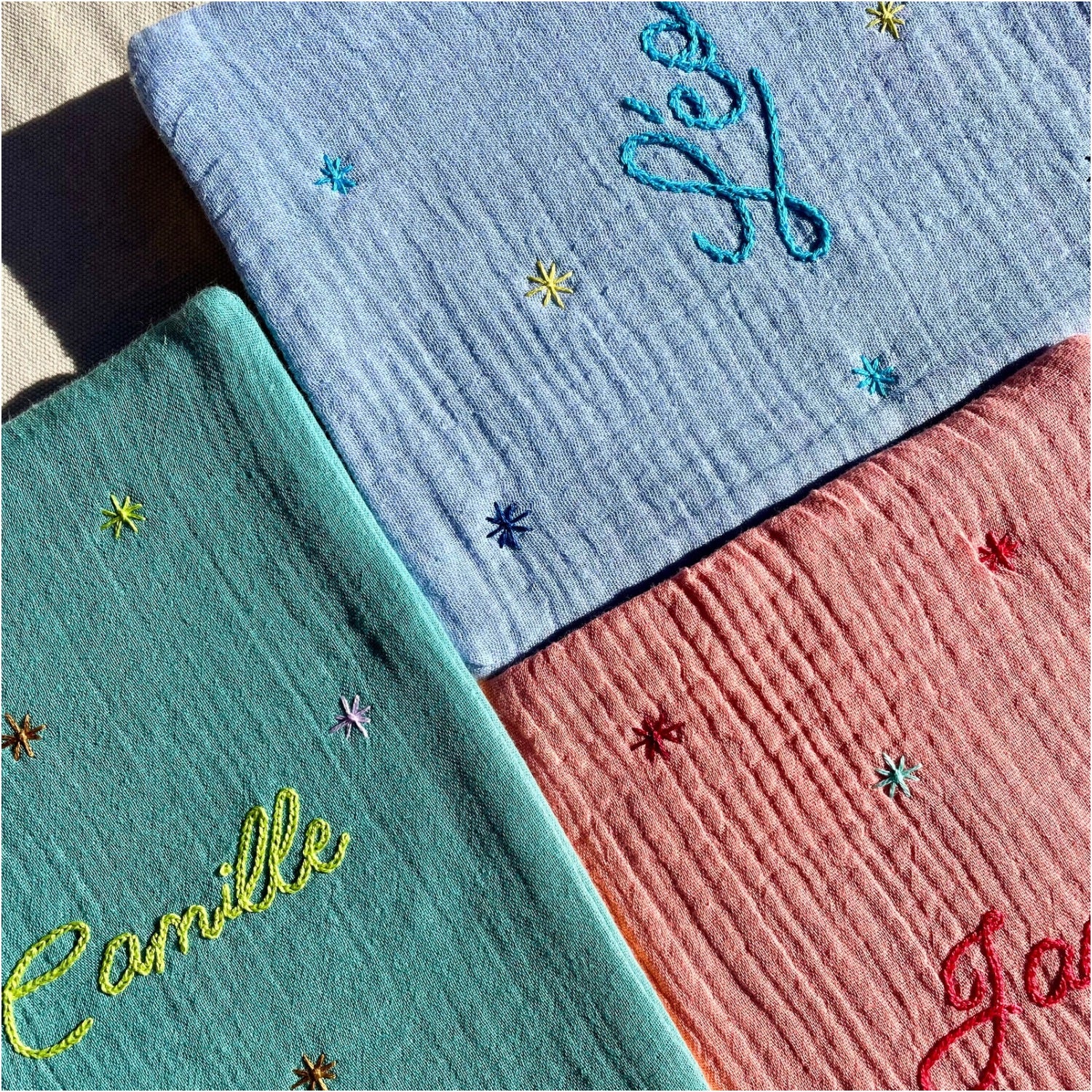 Aperçu de protège-carnets de santé bébé brodés et personnalisés, en gaze de coton, déclinés en plusieurs coloris, réalisés à la main en France par Savane Paris.