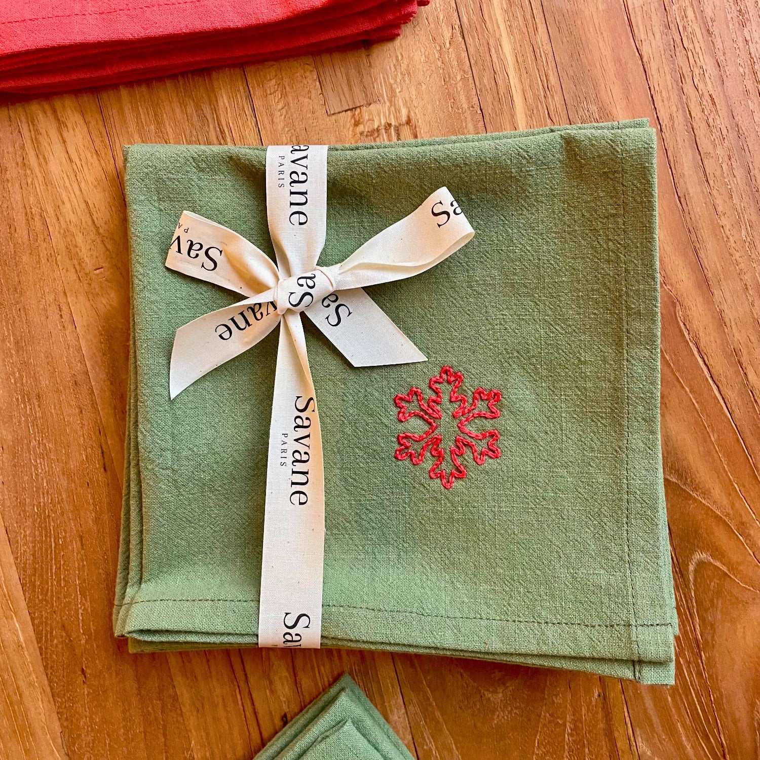 Serviettes de table de Noël vertes brodés motif flocon de neige, présentés en lot et emballés avec un ruban cadeau Savane