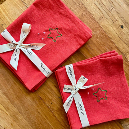 Set et serviettes de table de Noël rouges brodés motif étoiles, présentés en lot et emballés avec un ruban cadeau Savane