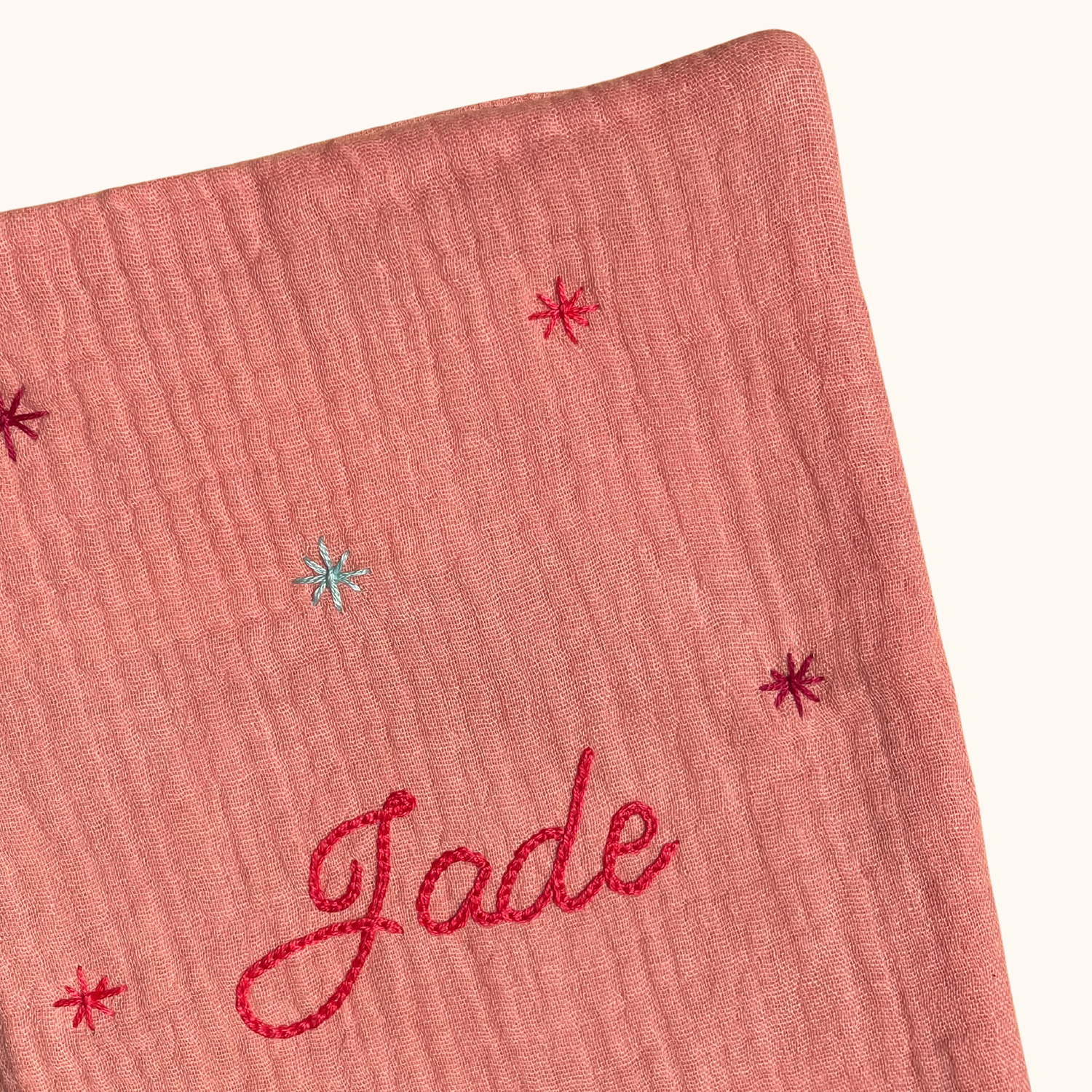 Gros plan sur les étoiles brodées à la main sur un protège carnet de santé rose personnalisé – création artisanale Savane Paris fabriquée en France.