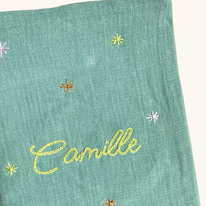 Gros plan sur les étoiles brodées à la main sur un protège carnet de santé vert personnalisé – création artisanale Savane Paris fabriquée en France.