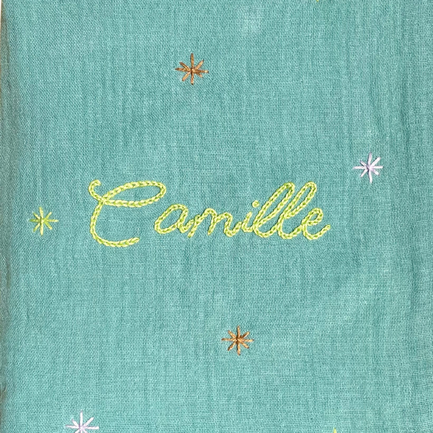 Zoom sur la broderie du prénom réalisée à la main sur un protège carnet de santé vert Savane Paris – fil DMC, savoir-faire artisanal français, cadeau de naissance personnalisé.